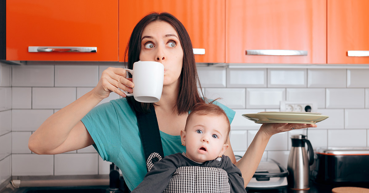 mother carrying baby holding coffee and eating breakfast