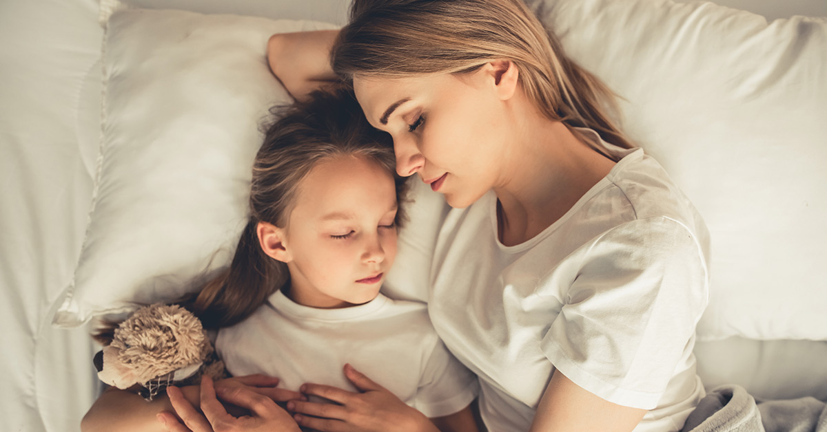 mother sleeping with daughter in bed