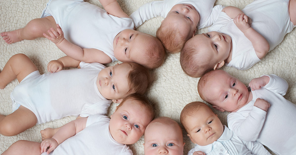 multiple babies laying down in a circle with their heads touching in the middle
