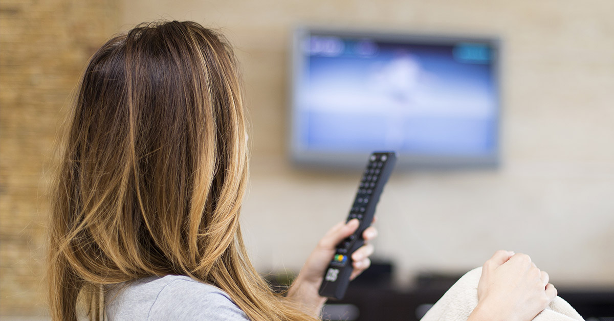 woman holding tv remote watching TV