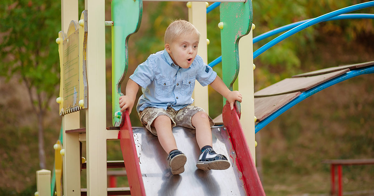 child with down syndrome going down slide