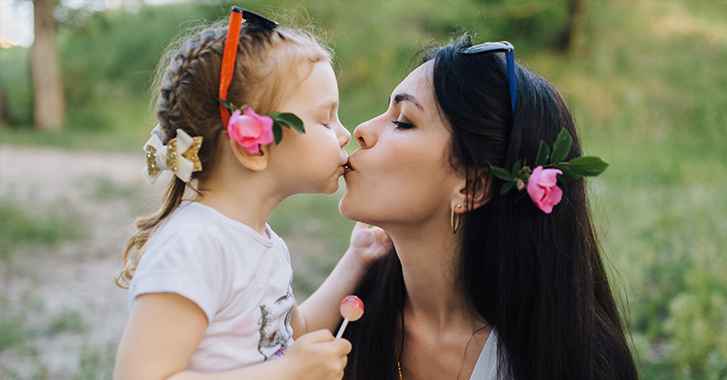 mom kissing daughter on the lips