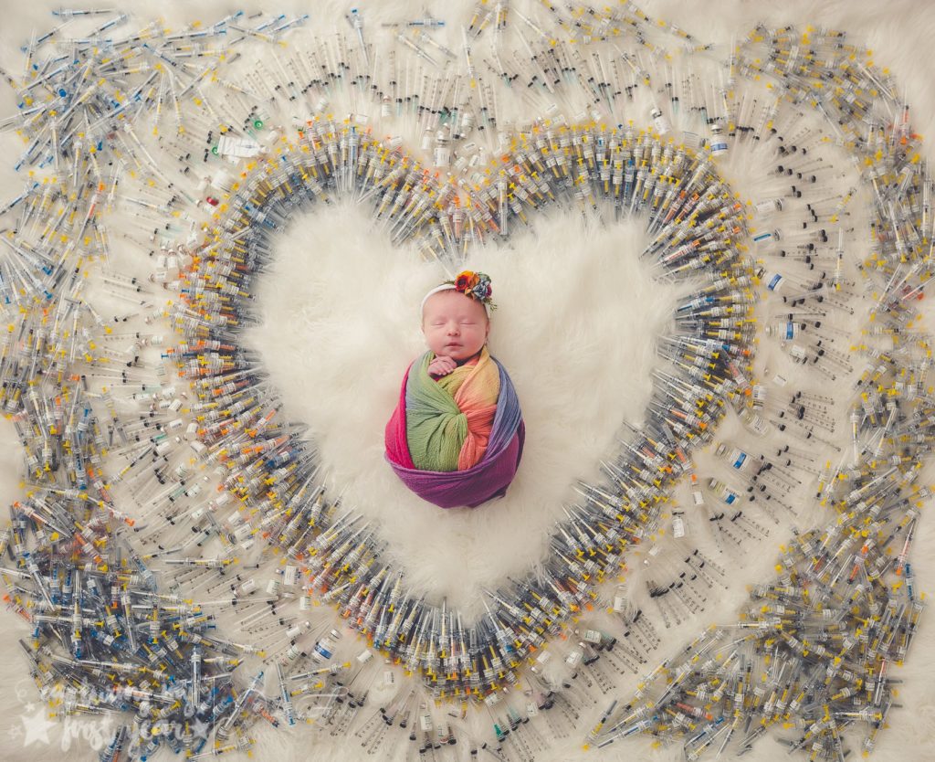 Young baby surrounded by the number of IVF needles needed to conceive and bring the infant to term. 