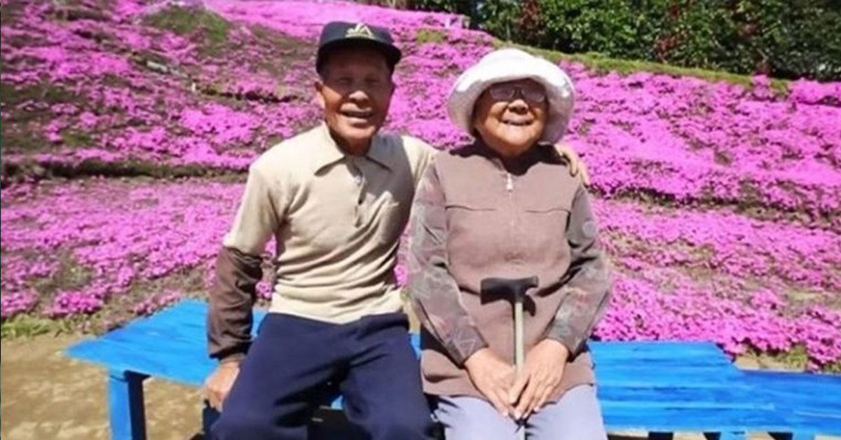 older couple in front of pink flowers