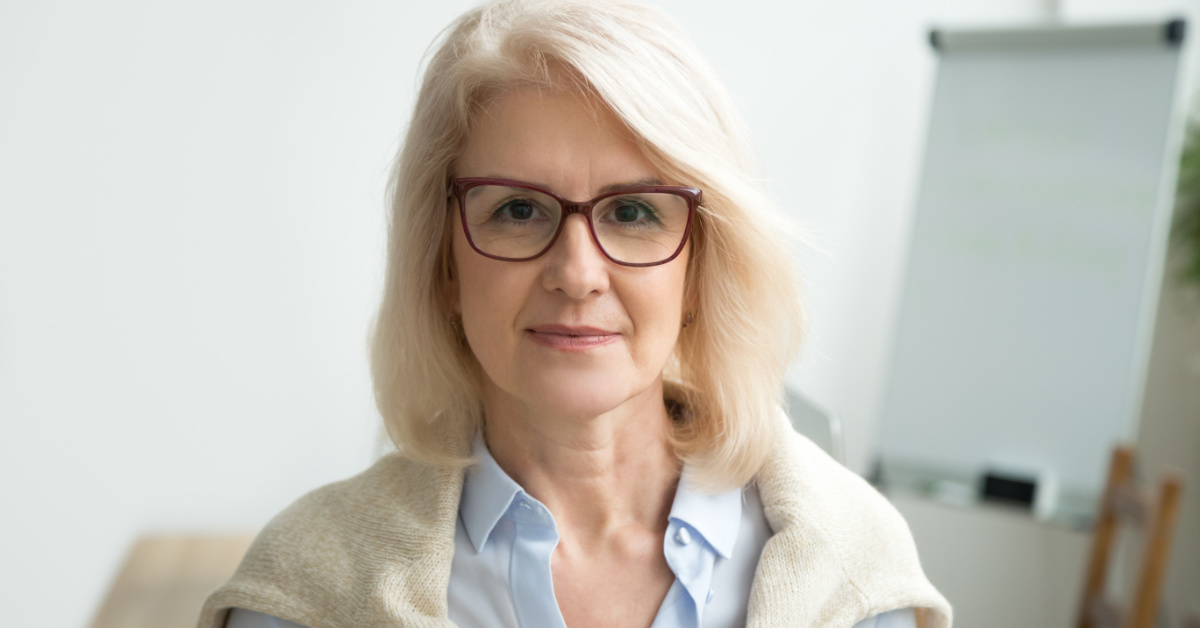middle aged caucasian woman with white hair and glasses