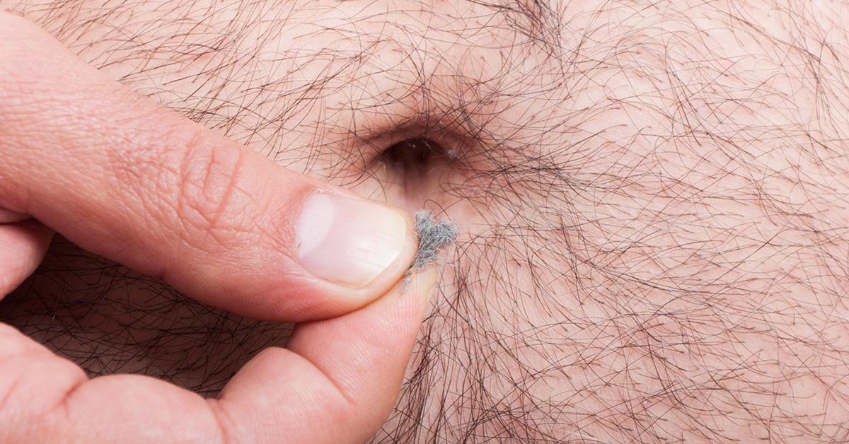 close of of belly button with lint being held between someones thumb and index finger
