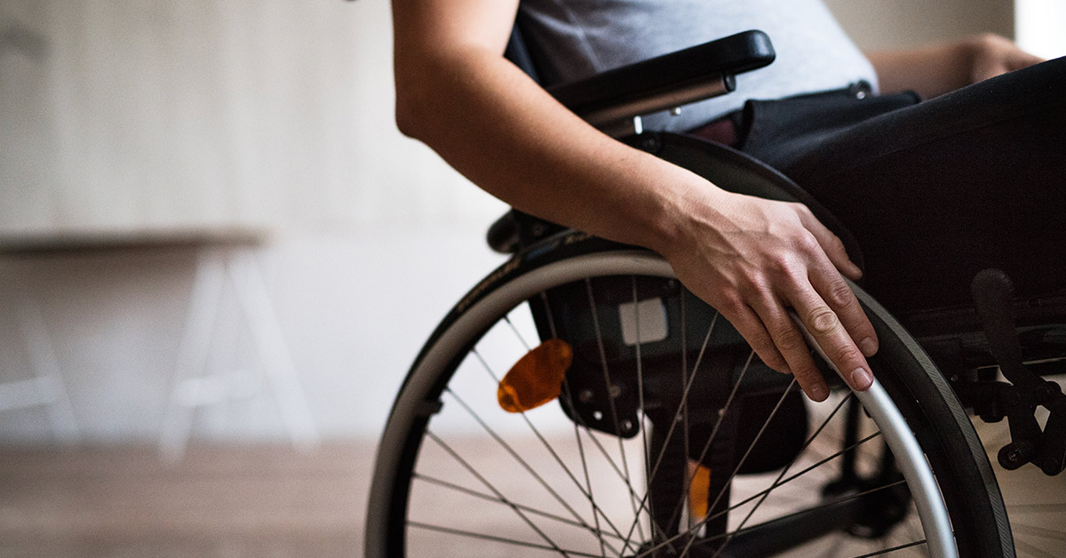 person in a wheelchair with hand placed on wheel