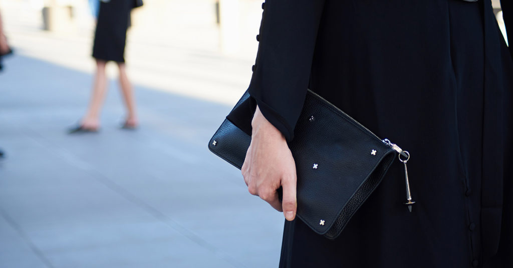 person holding black purse 