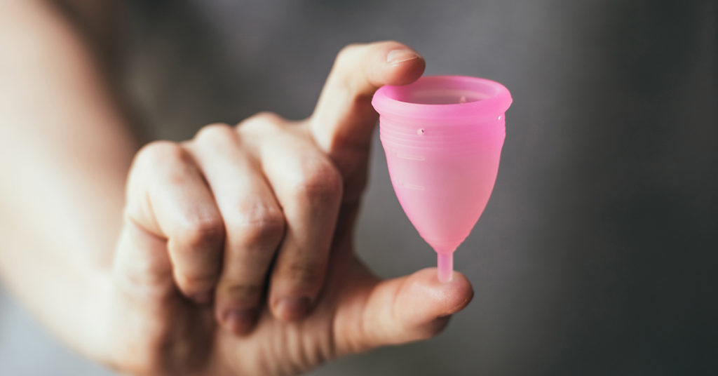 hand holding reusable menstrual cup 