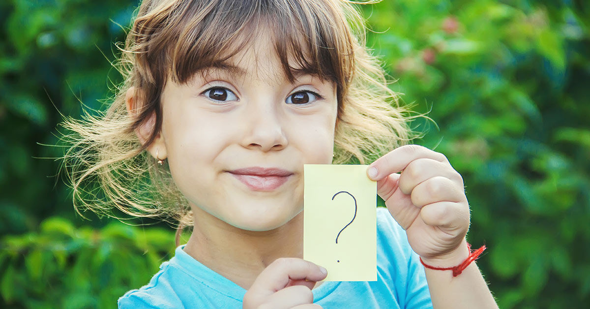 child holding a sticky note with a question mark