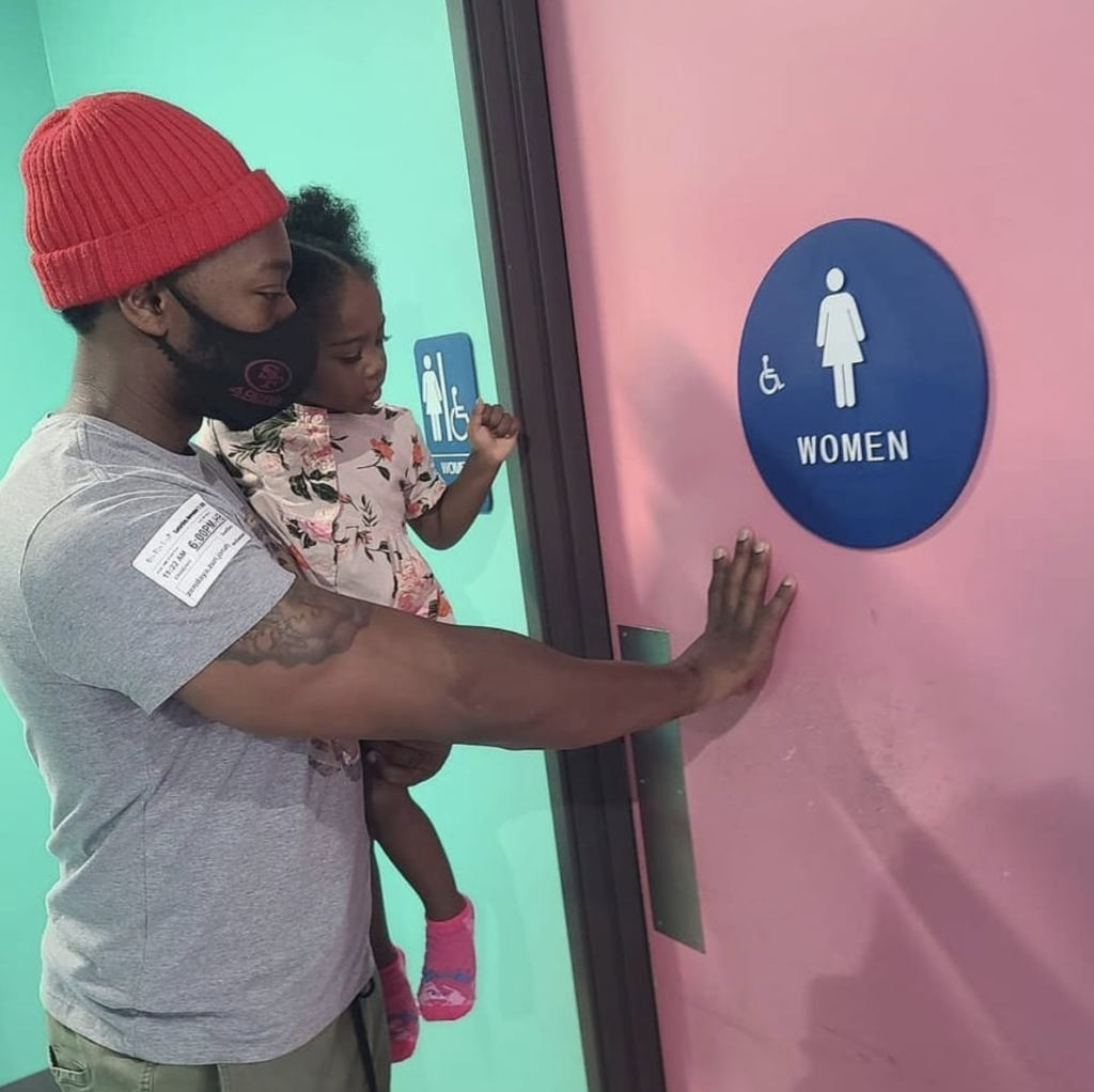Muhammed Nitito using the women's bathroom with his daughter Zuri