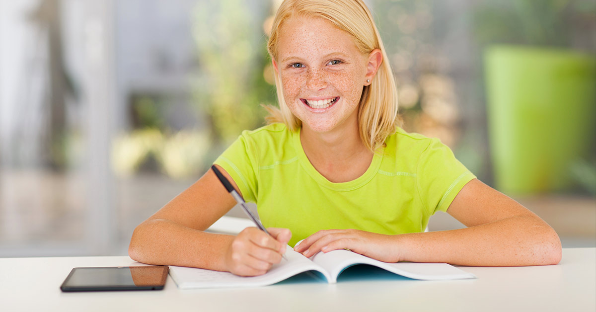 smiling blond child doing homework