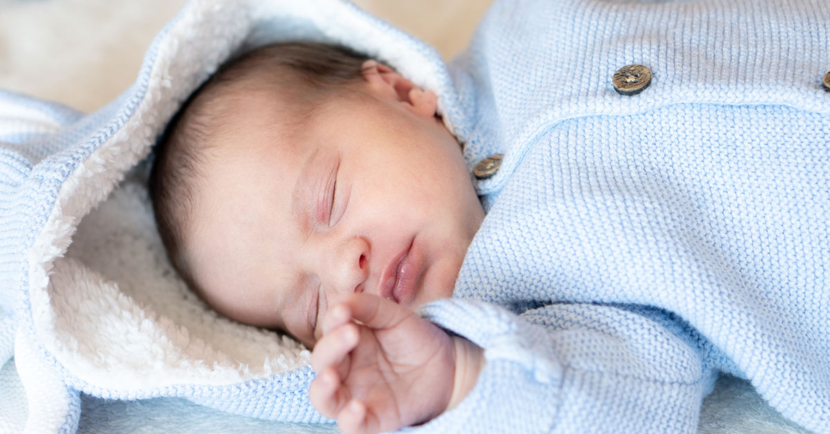 newborn sleeping in light blue clothing