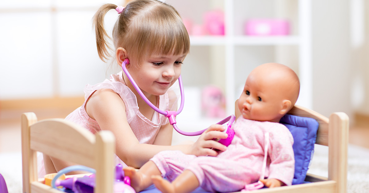 girl playing doctor with doll