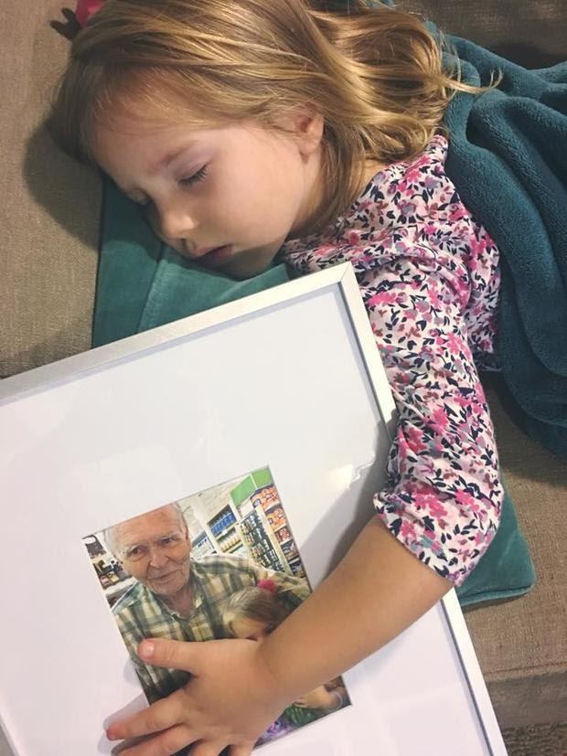 Nora Wood sleeping holding a framed image of her and Dan Peterson