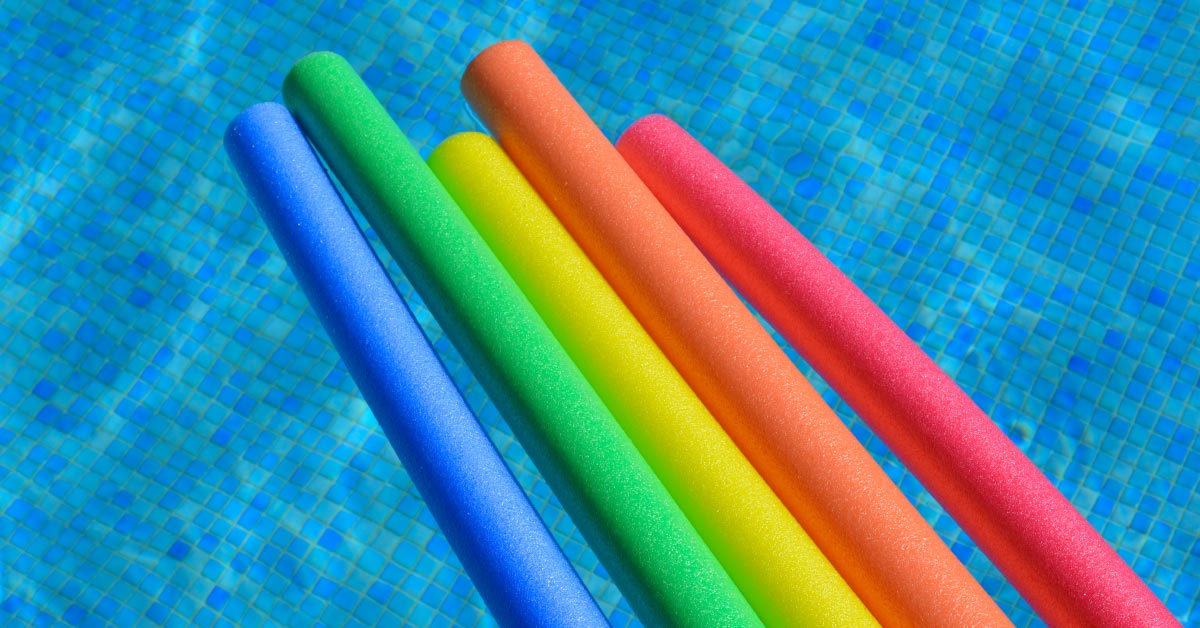 various color pool noodles floating in a pool