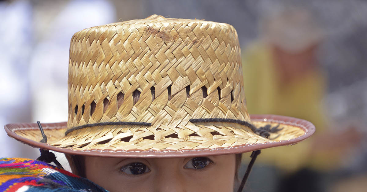 young child in wicker hat