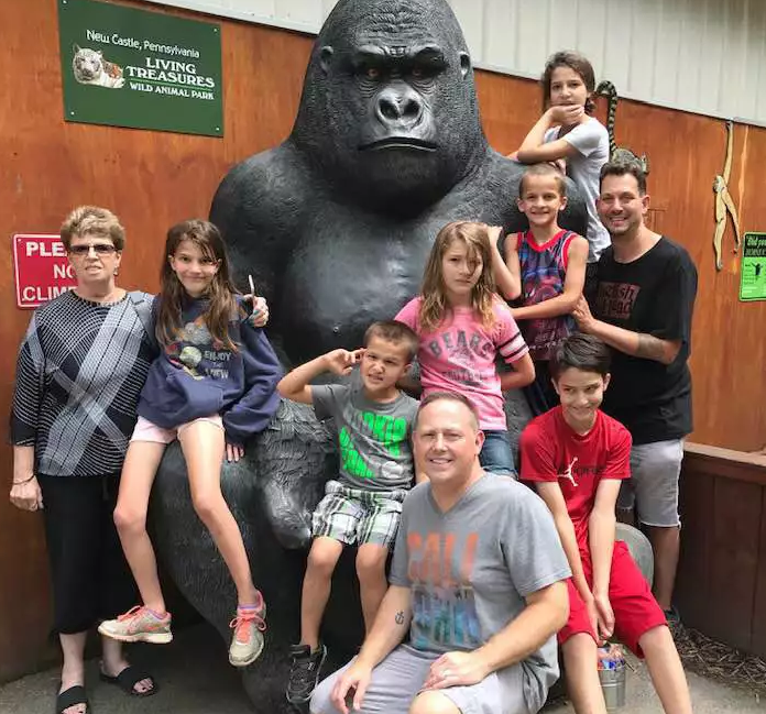 Anderson-McClean Family posing with a gorilla statue 