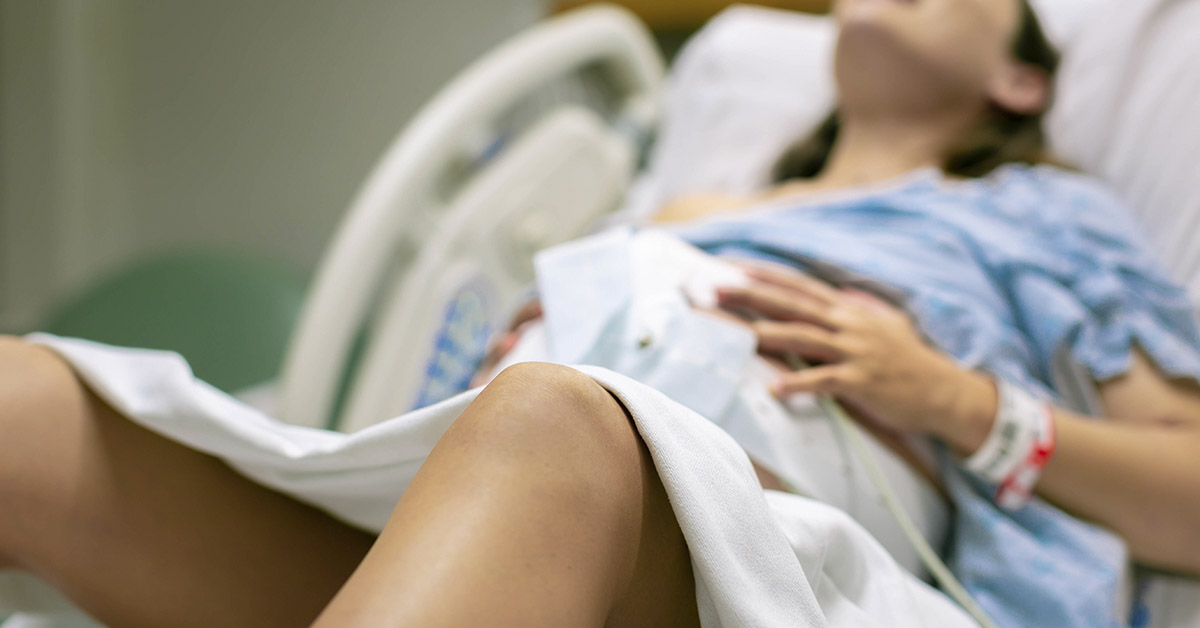 pregnant woman in hospital gown and bed