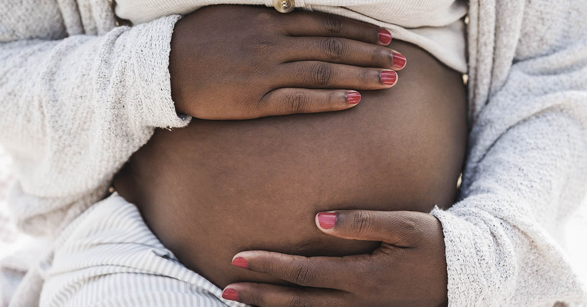 black pregnant woman holding belly