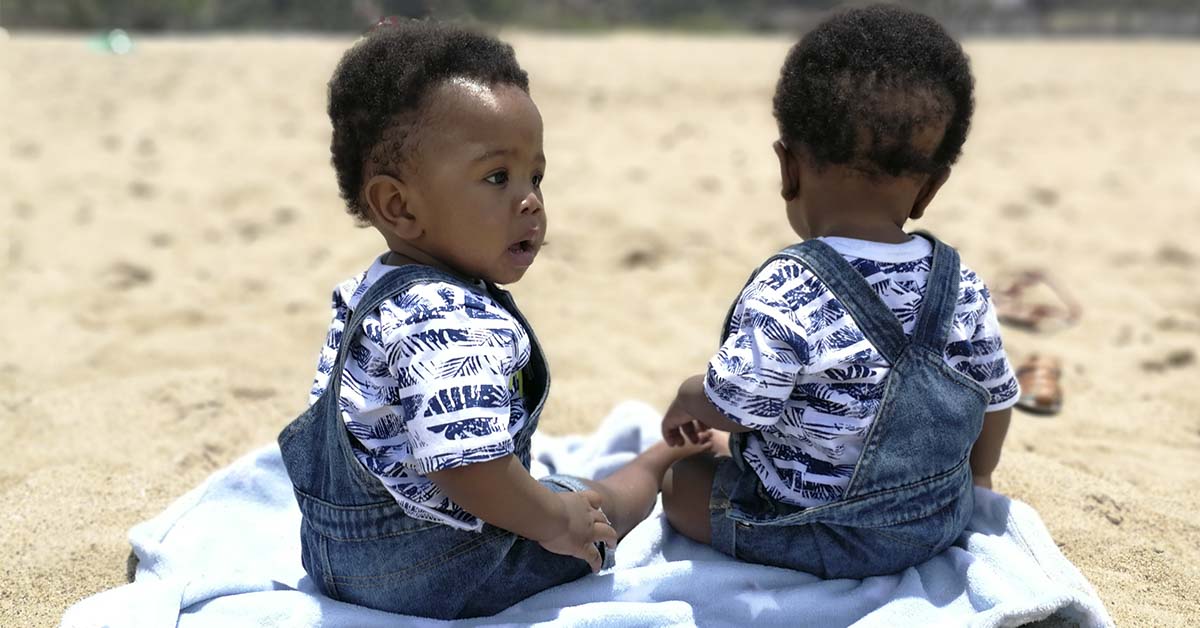 infant twins on beach