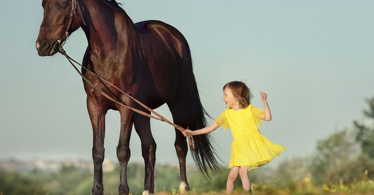 young girl in yellow dress with horse