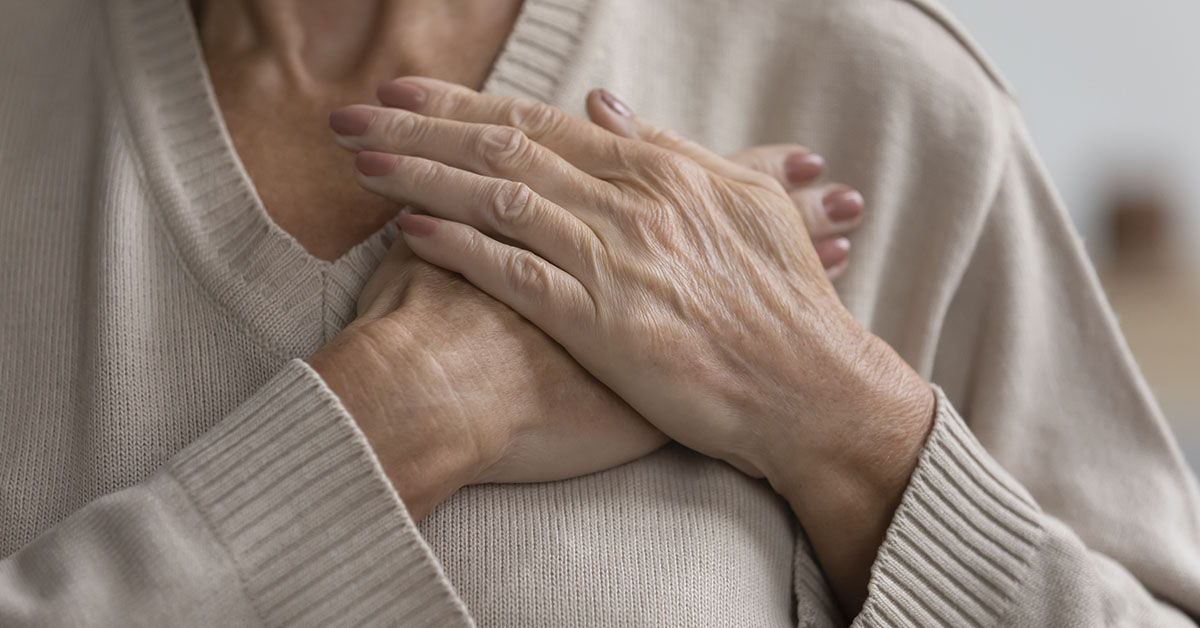 elderly woman putting hands over chest