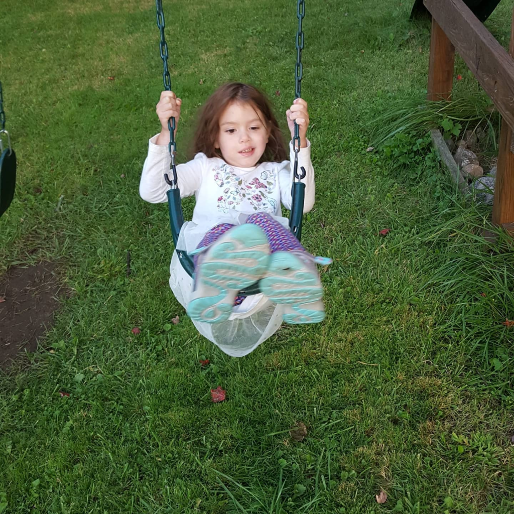 Zoey playing on swings