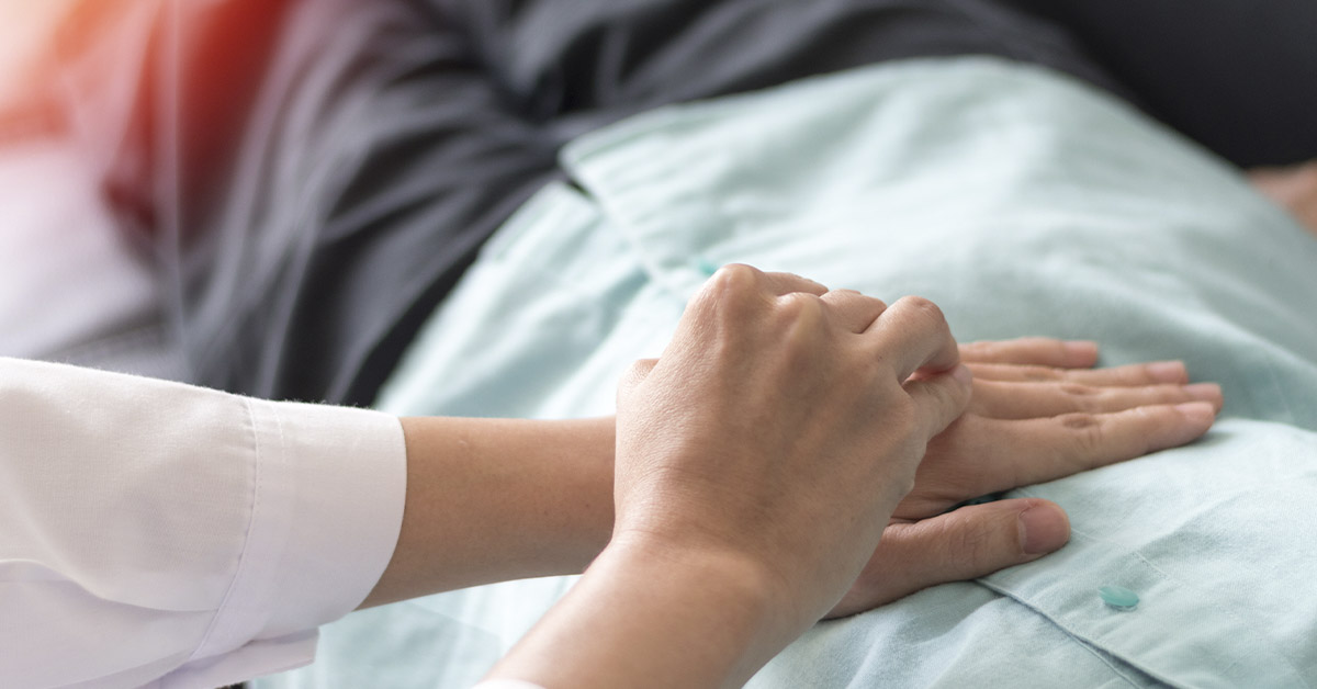 holding a hospital patients hands for comfort