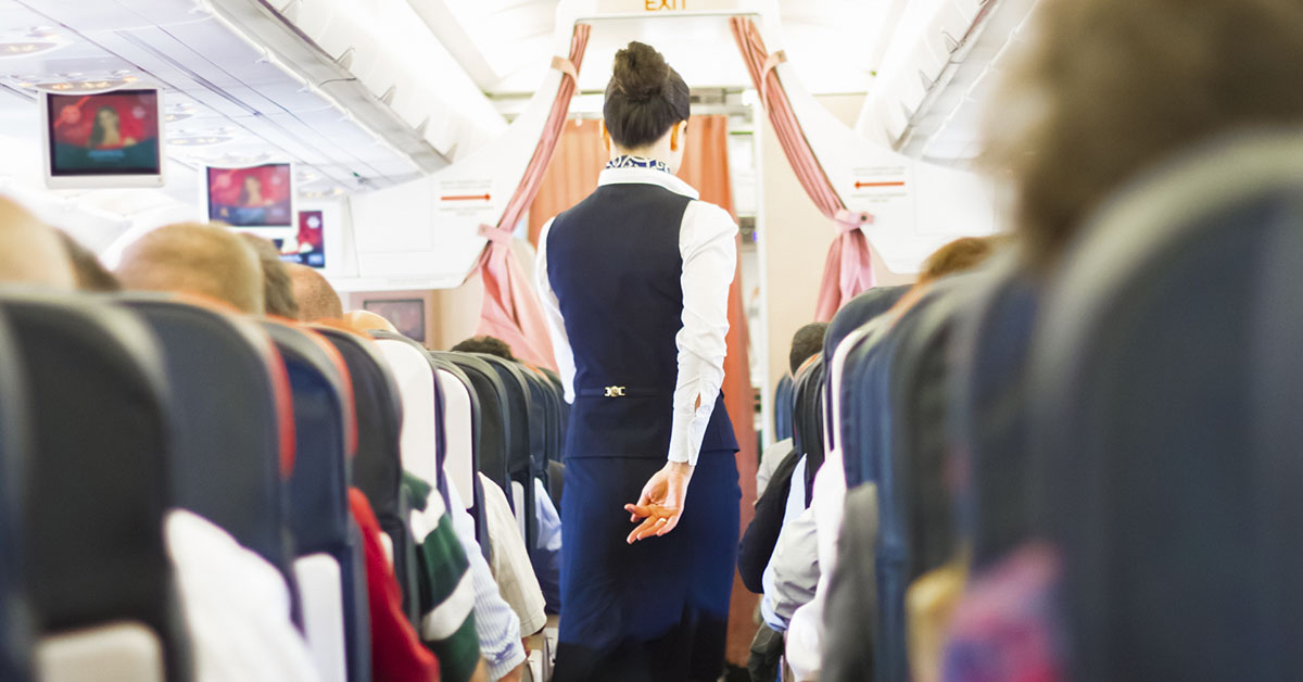 airline attendant walking down aisle in plane