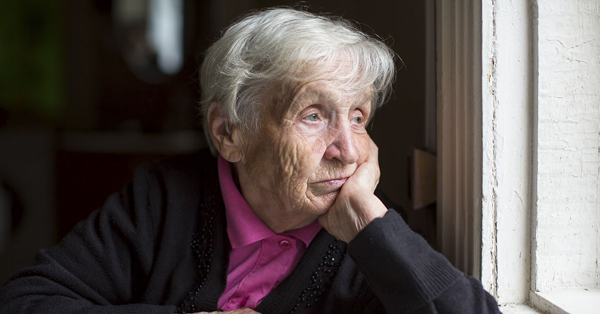 an elderly woman looking out a window in dismay