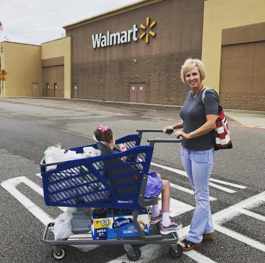 Drew posing outside of Wamart with her daughter Caroline in one of her specially designed shopping carts
