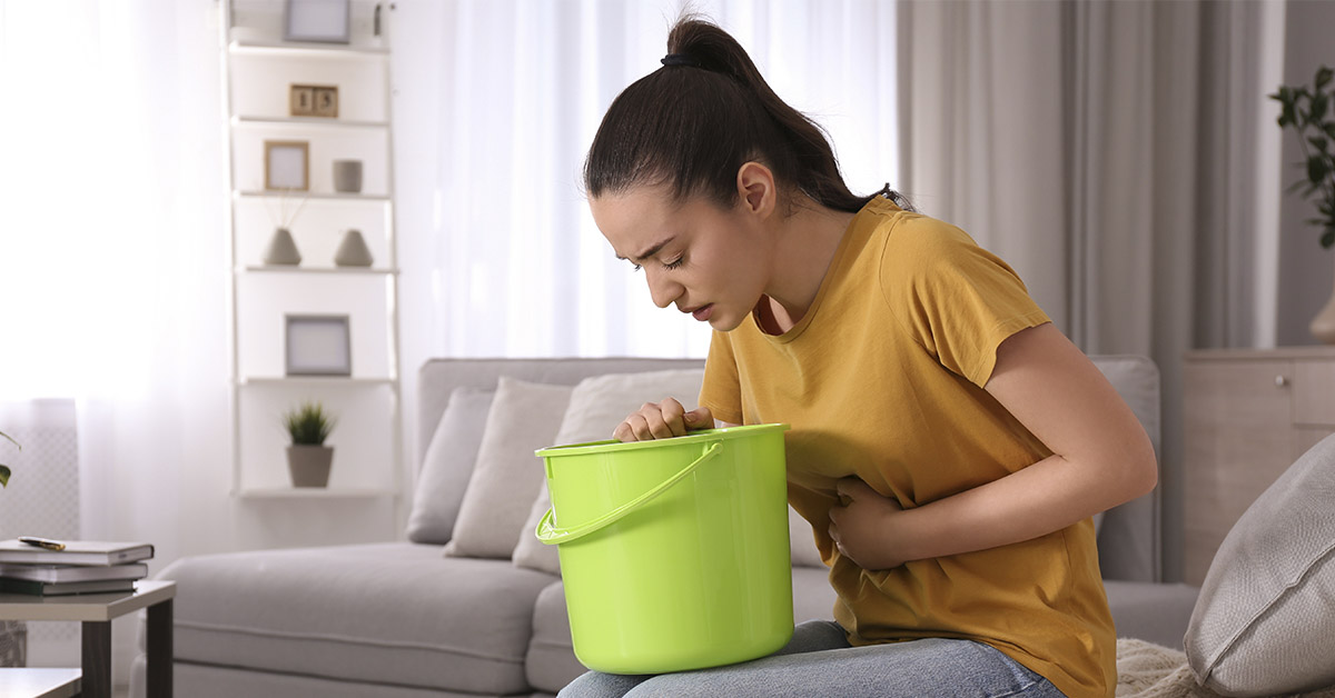 woman about to vomit in bucket