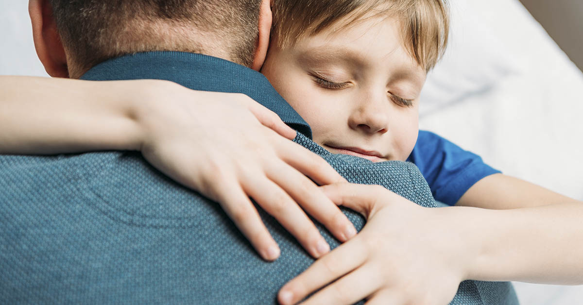 boy hugging father