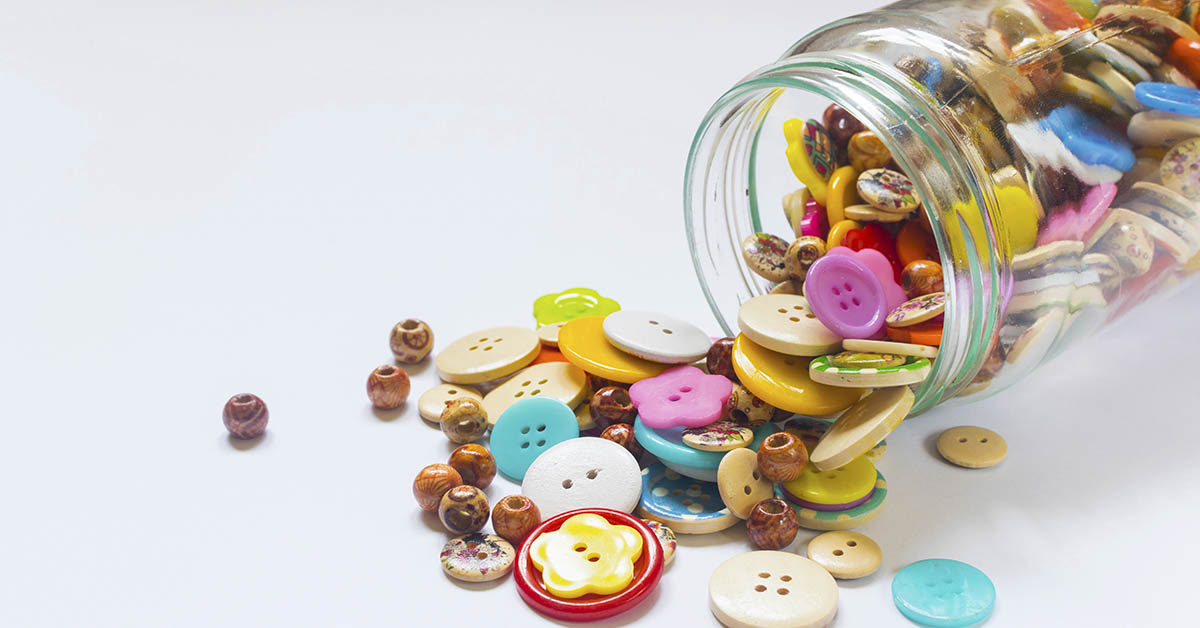 jar of buttons spilled onto a white surface
