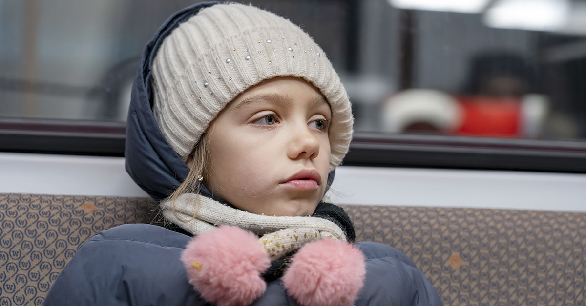 child dressed in winter clothing while riding the subway