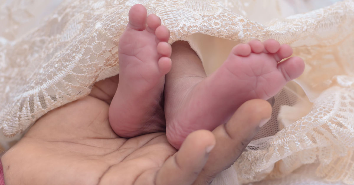 baby's feet being held by adult hand
