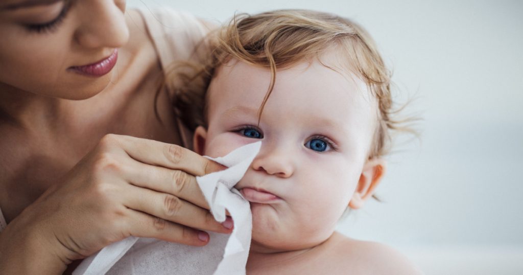 Mother Wiping Baby's Face with wet wipe