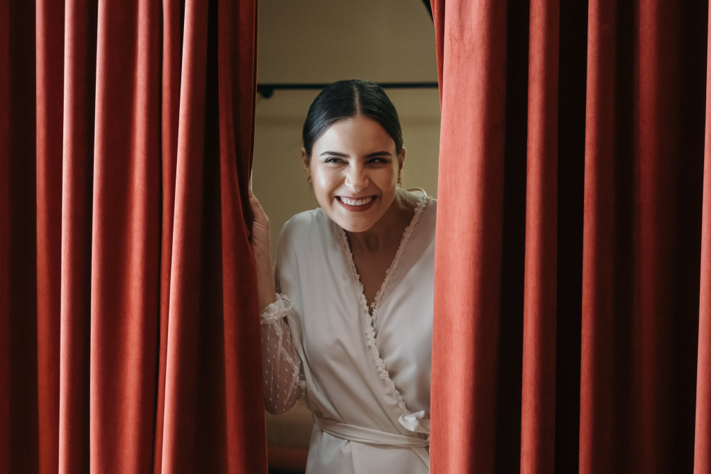 smiling woman opening curtains