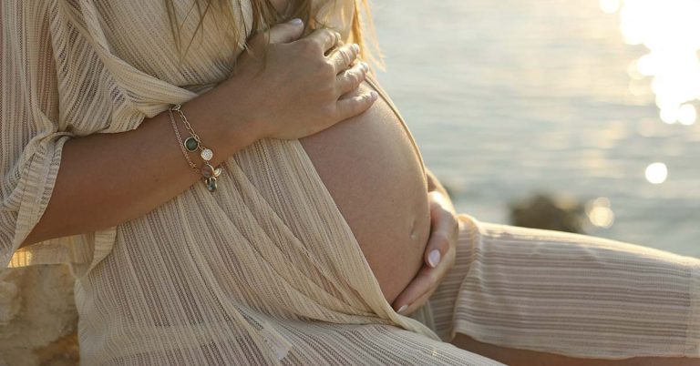 Woman who flew 4,000 miles to give birth on beach now stranded with her baby - Featured image