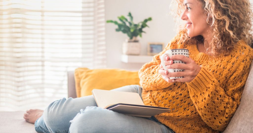 Woman have relax at home with cup of tea and book