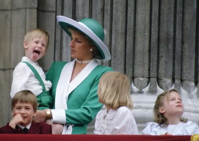 With her son Harry, wearing matching outfits as he points out his tongue to the crowd