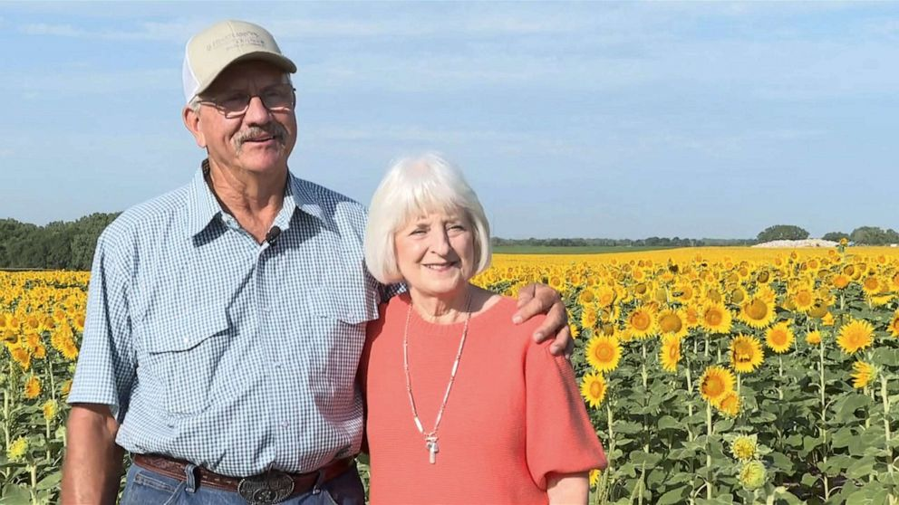 Lee and Renee Wilson in front of the sunflower field prepared for their anniversary.