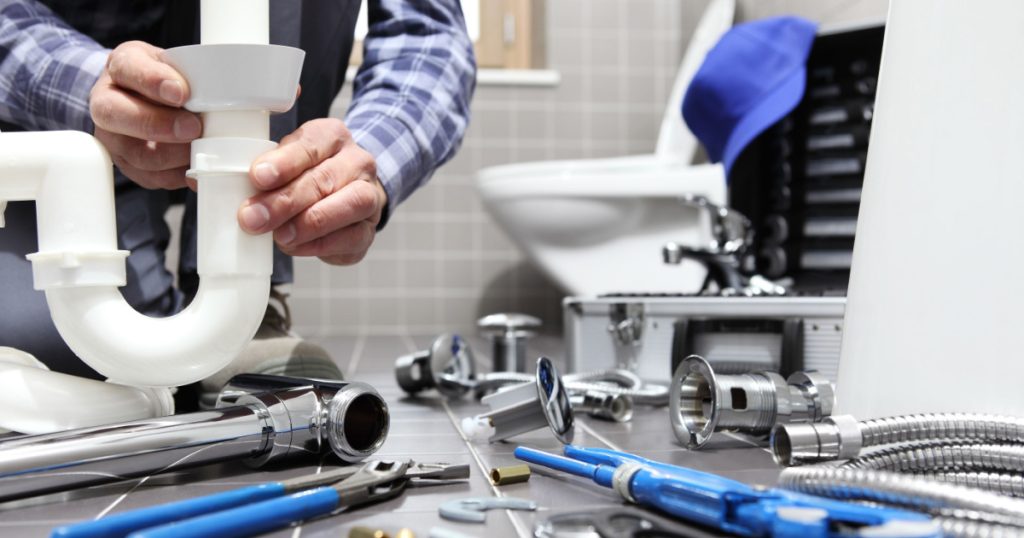 plumber at work in a bathroom, plumbing repair service, assemble and install concept

