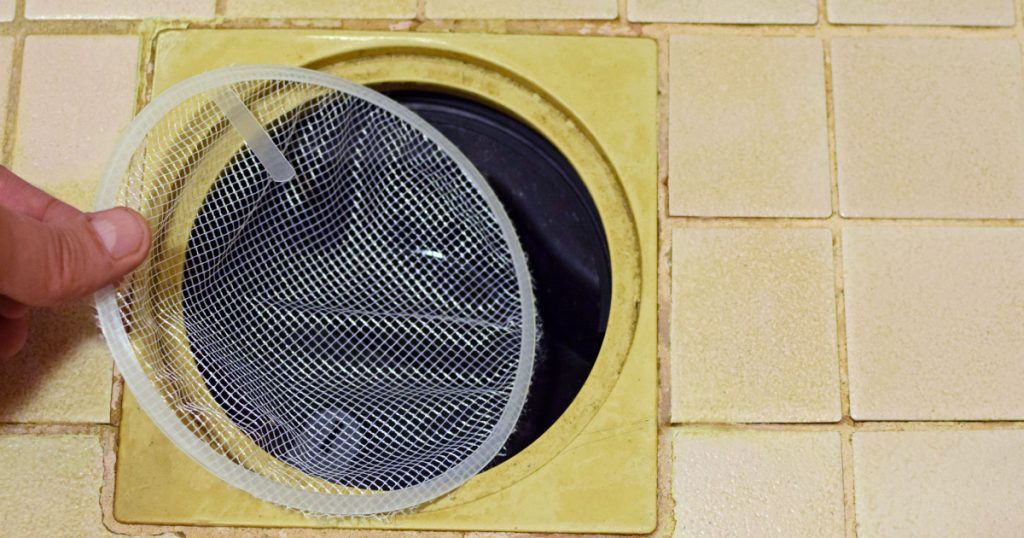 Installing hair catcher filter net to shower drain.