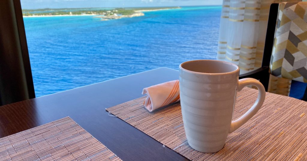 A cup of coffee on a table overlooking the beautiful turquoise waters of the Bahamas.
