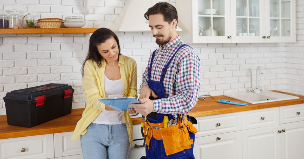 Male mechanic or repairman close deal with female client after work or fix at home. Man plumber or engineer get woman customer sign contract for repair. Plumbing and maintenance.