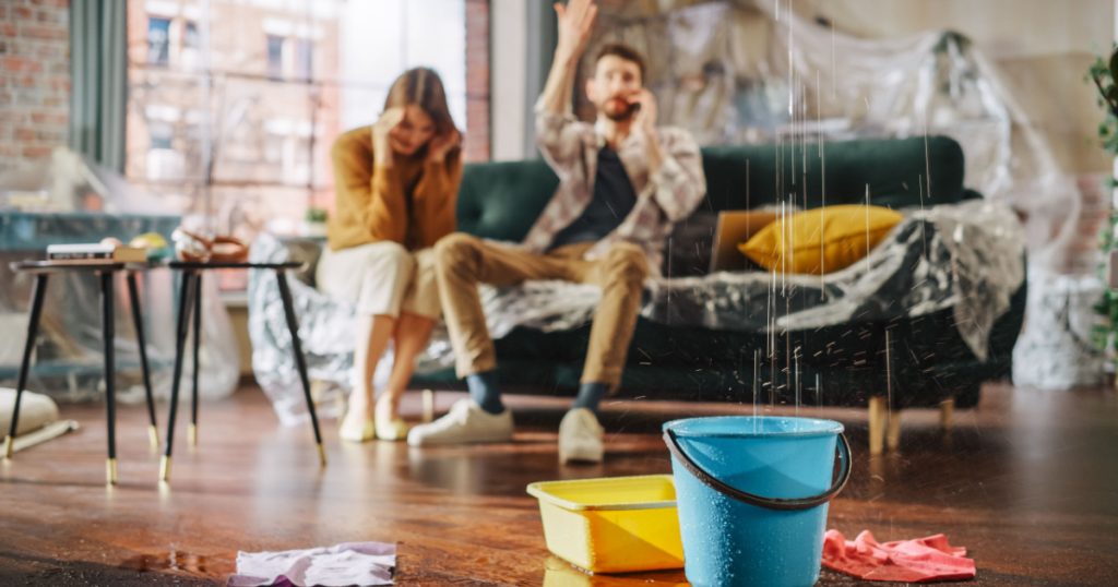 Roof is Leaking, Pipe Rupture at Home: Angry Couple Calling Insurance Company, Screaming into Phone in Frustration, Trying to Find Plumber, Master. Water Drips into Buckets in Living Room. Rack Focus
