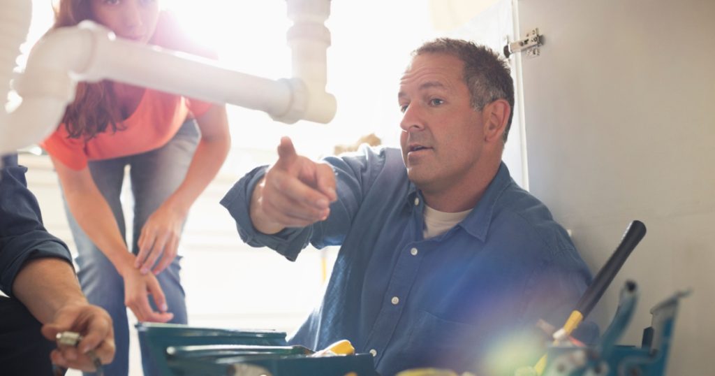 plumber pointing at pipe