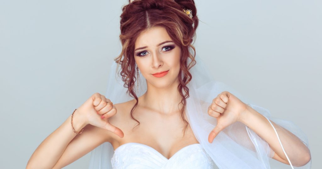 Unhappy bride. Woman with thumbs down gesture isolated light blue background wall. Studio shot horizontal image. Body language, human emotion ace expression